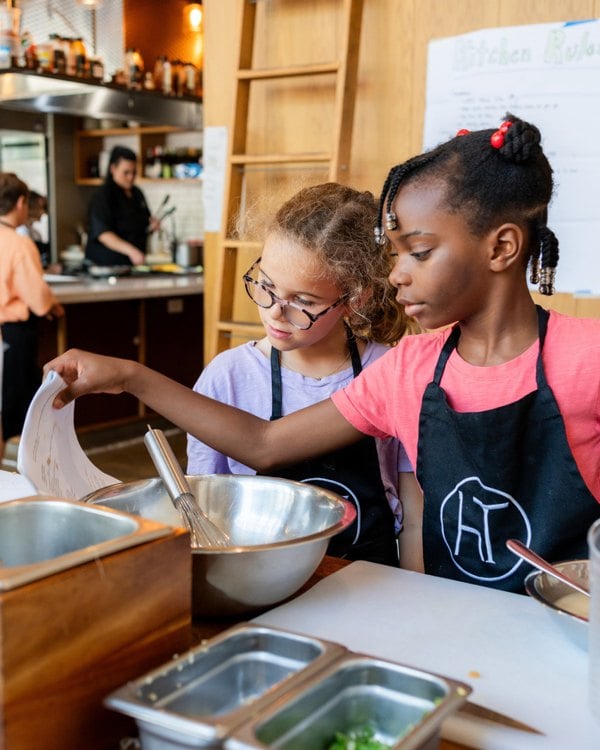 Young chefs preparing food in a Hudson Table cooking class